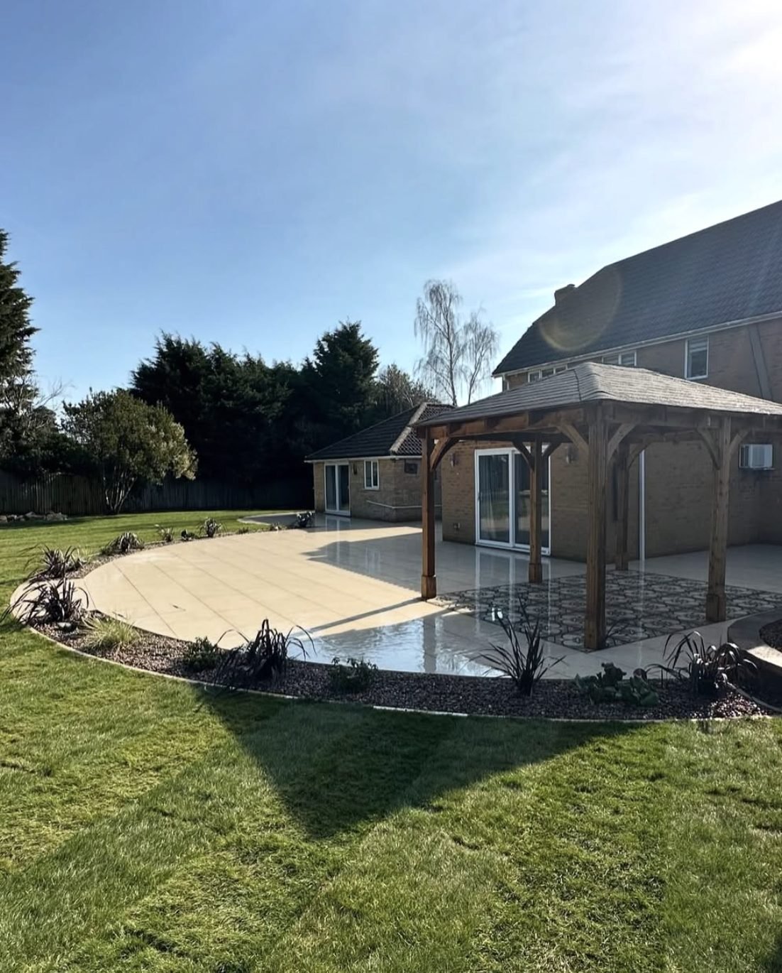 Curved porcelain patio with oak gazebo installed by landscape gardeners Belfast